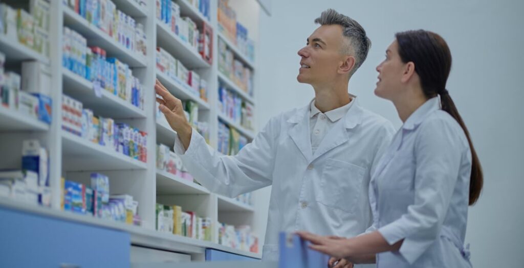two druggists in lab coats in the process of inventory in a drugstore