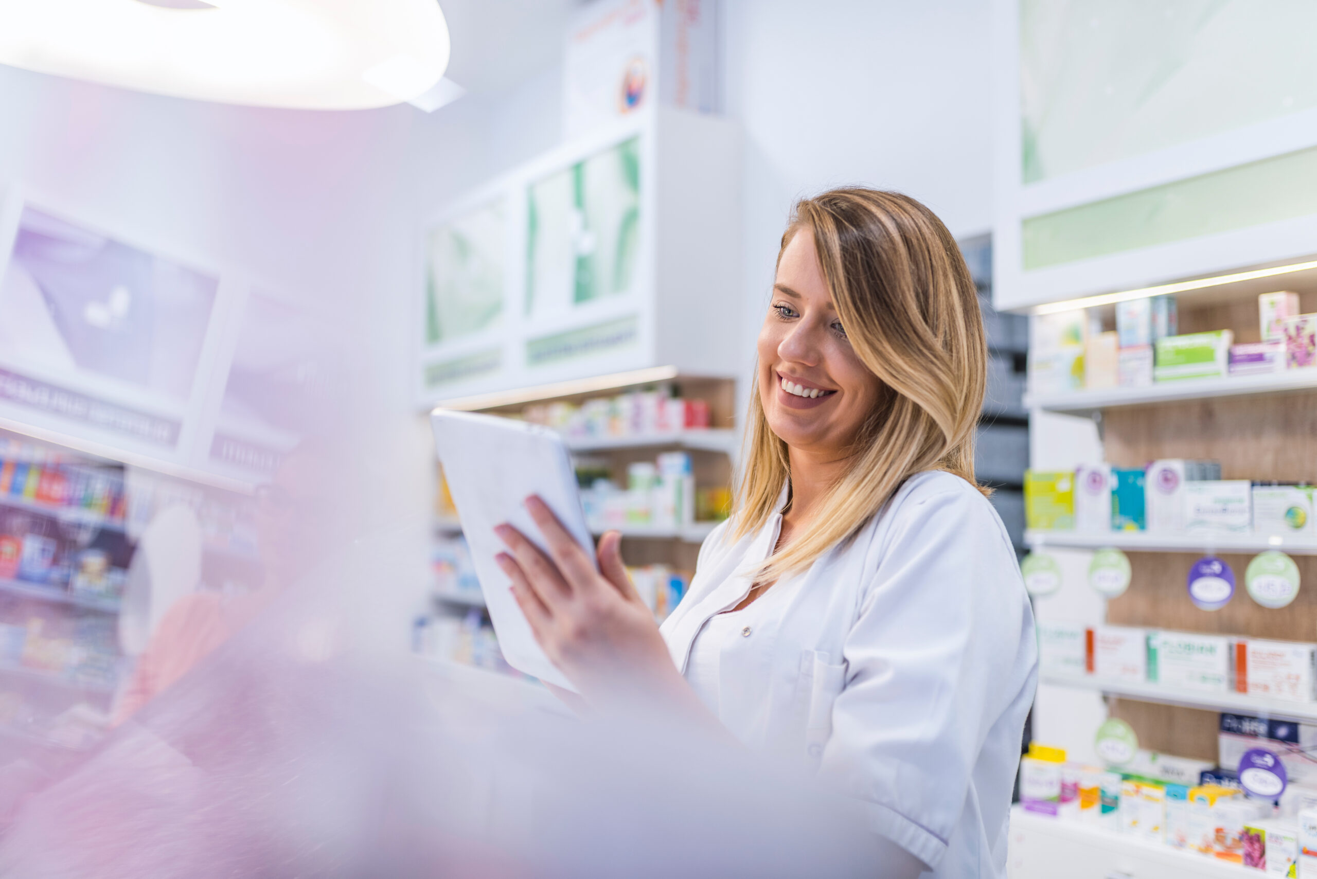 landingpage für apotheker pharmacist working with a tablet computer in the pharmacy holdin