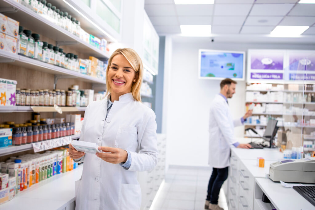 portrait of beautiful female pharmacist standing in pharmacy sto