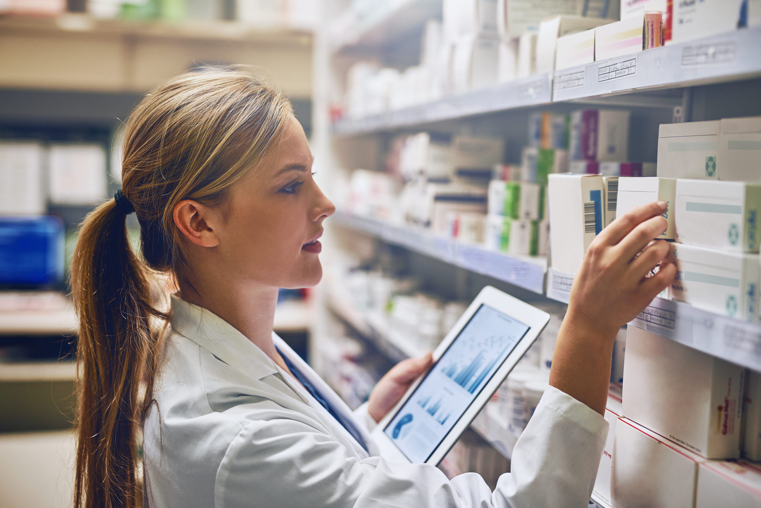 according to this online tool, this medication will work best. shot of a pharmacist using her digital tablet while working in a isle.